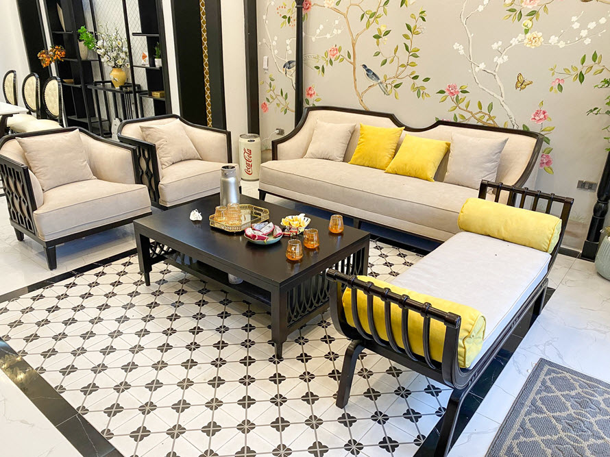 toàn cảnh phòng khách với bàn trà màu đen, sofa bọc nệm màu be, tranh tường đẹp