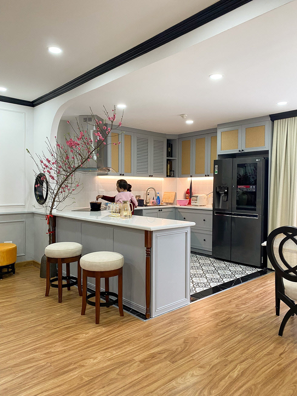 Bếp chữ U ẩn mình sau khung vòm mềm mại. Bàn bếp kéo dài thành bàn đảo tách biệt với không gian bên ngoài.