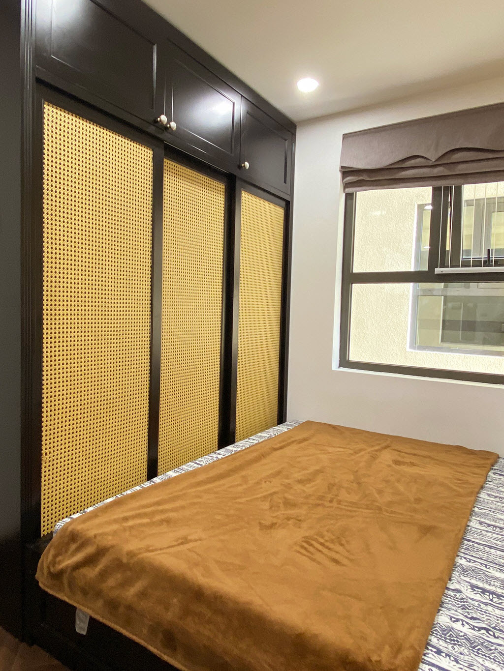 Thay v&igrave; kiểu cửa tủ đ&oacute;ng k&iacute;n, kiến tr&uacute;c sư chọn cửa m&acirc;y tre đan tho&aacute;ng đ&atilde;ng, tạo cảm gi&aacute;c th&acirc;n thiện hơn.