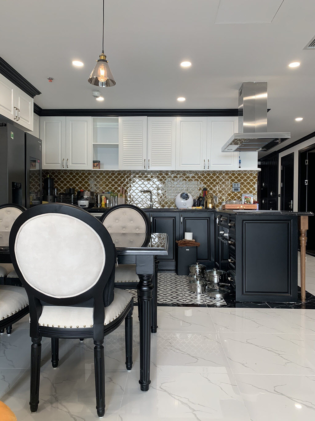 Tủ bếp tr&ecirc;n m&agrave;u trắng gi&uacute;p c&acirc;n đối bảng m&agrave;u với sắc đen chủ đạo trong ph&ograve;ng bếp.