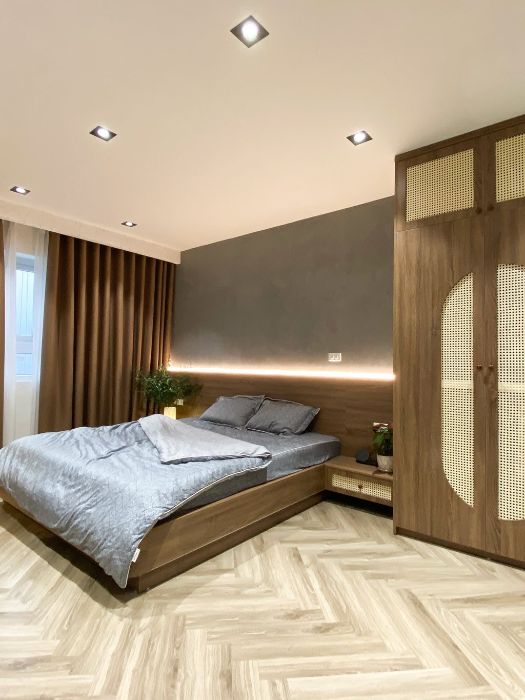 Đ&egrave;n LED trang tr&iacute; đầu giường cung cấp &aacute;nh s&aacute;ng vừa đủ cho ph&ograve;ng ngủ, đồng thời tạo điểm nhấn ấm &aacute;p tr&ecirc;n nền tường b&ecirc; t&ocirc;ng x&aacute;m.