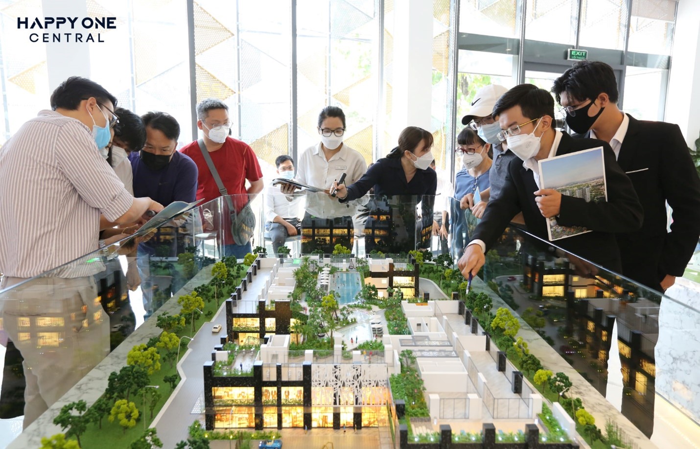 A group of people looking at a model of a cityDescription automatically generated with medium confidence