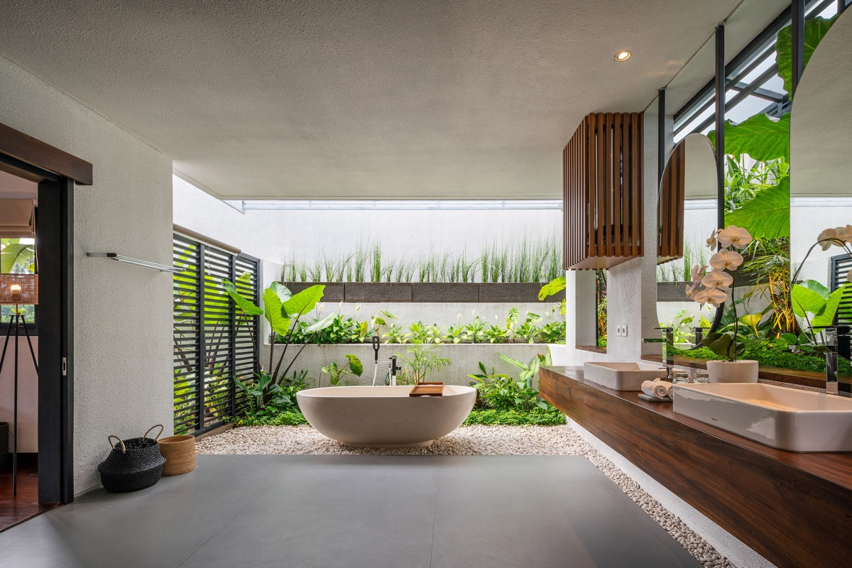 Trên nền xám đá mát mẻ và màu gỗ ấm áp, cây xanh nhiệt đới mang đến bầu không khí tươi vui, tràn đầy năng lượng.