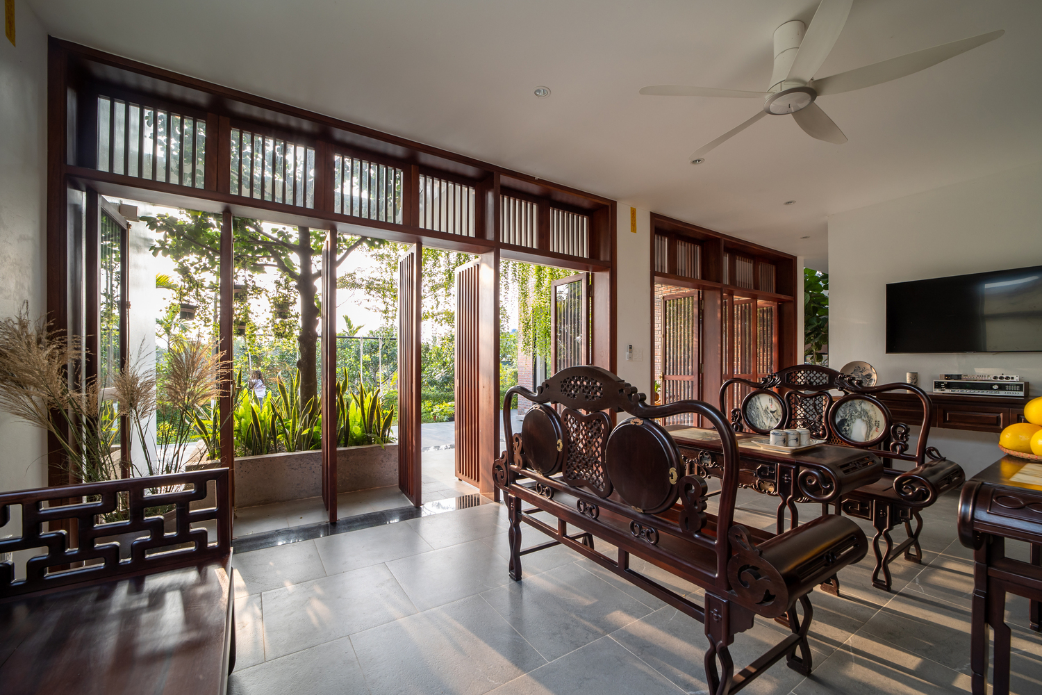 phòng khách với bộ sofa gỗ truyền thống chạm khắc cầu kỳ tinh tế