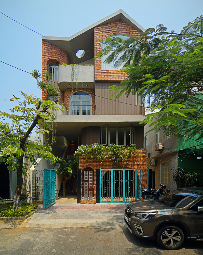 hình ảnh toàn cảnh ngôi nhà Mộc ở Đà Nẵng với những bức tường gạch đỏ hút mắt, cửa vòm kiểu châu Âu ấn tượng.