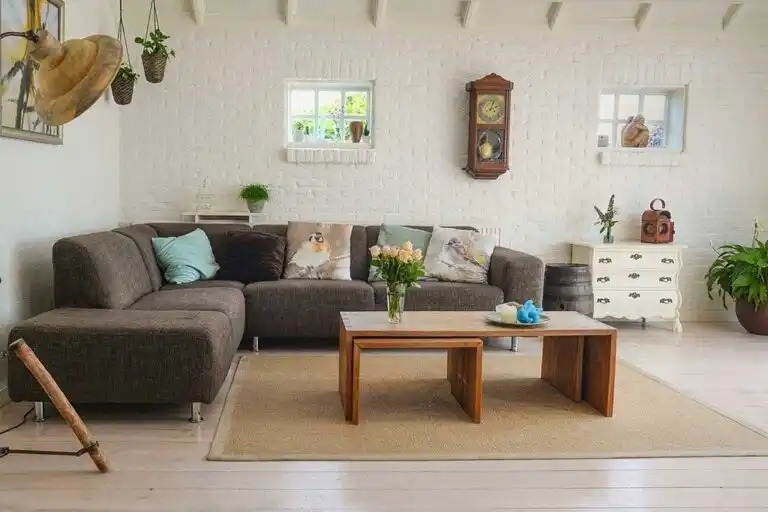 ph&ograve;ng kh&aacute;ch với sofa m&agrave;u x&aacute;m, tường trắng, cửa sổ k&iacute;nh,c hậu c&acirc;y treo