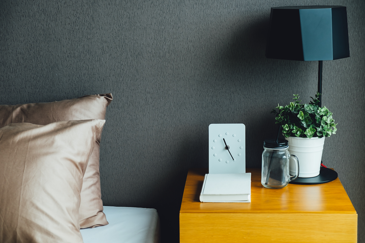 B&agrave;n phụ b&agrave;ng gỗ m&agrave;u s&aacute;ng tạo sự tương phản th&uacute; vị với giấy d&aacute;n tường. Tại đ&acirc;y, bạn c&oacute; thể đặt s&aacute;ch b&aacute;o, đồng hồ, vật dụng c&aacute; nh&acirc;n nhỏ v&agrave; chậu cảnh trang tr&iacute;.