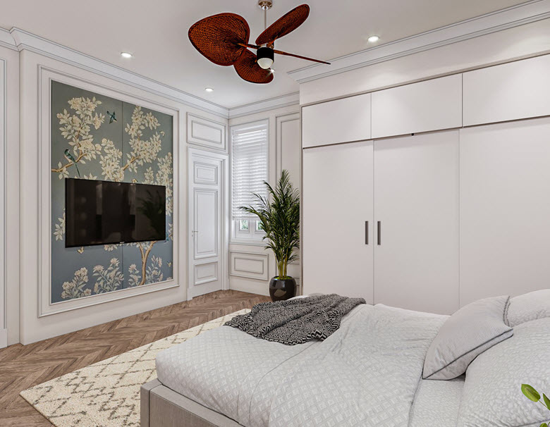Đối diện với giường ngủ là tivi được treo trực tiếp trên tường, kết hợp ăn ý cùng bức tranh phong cách Indochine ấn tượng. Hệ tường được bố trí khung vòm trang trí kiểu Tân cổ điển hòa hợp với tổng thể nội thất nhà phố.