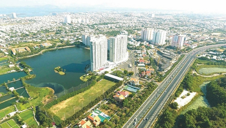 Một g&oacute;c th&agrave;nh phố nh&igrave;n từ tr&ecirc;n cao với hồ nước, c&aacute;c t&ograve;a cao ốc, xen kẽ c&acirc;y xanh