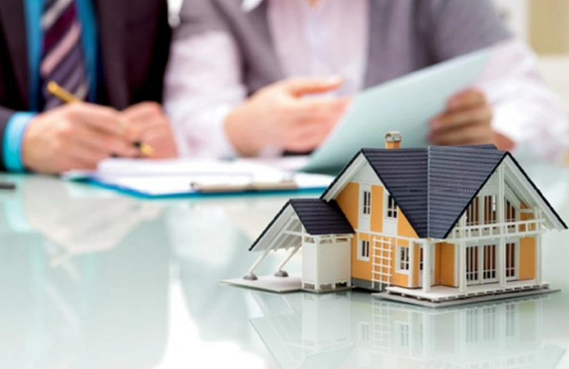 hình ảnh mô hình ngôi nhà đặt trên bàn minh họa cho hoạt động chuyển nhượng bất động sản