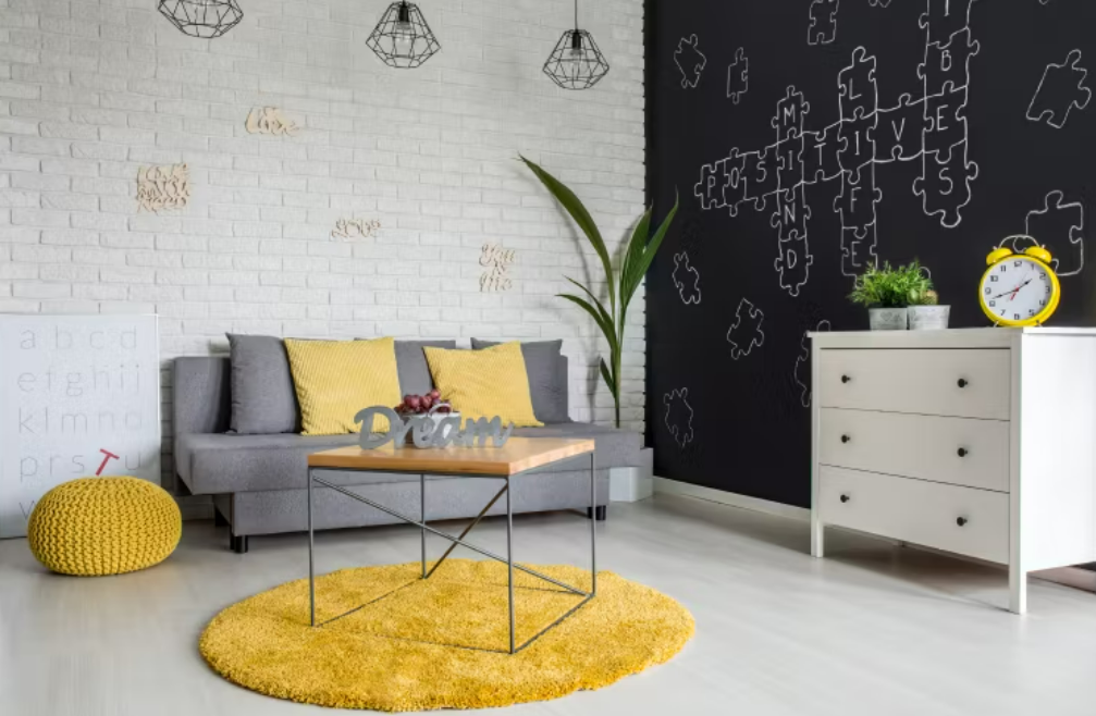 Một tấm thảm đầy màu sắc tạo điểm nhấn tươi vui cho phòng trọ màu trung tính chủ đạo.