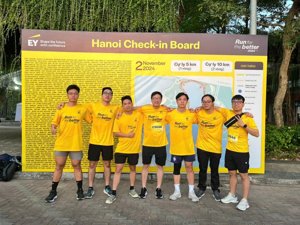 A group of men in yellow shirts posing for a photo  Description automatically generated