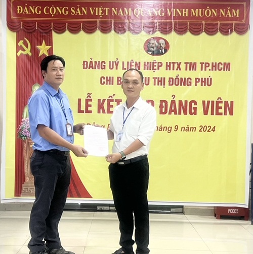 Bí thư chi bộ, Giám đốc Co.opmart Đồng Phú Nguyễn Quốc Minh trao quyết định kết nạp Đảng đối với quần chúng ưu tú Nguyễn Thành Công.