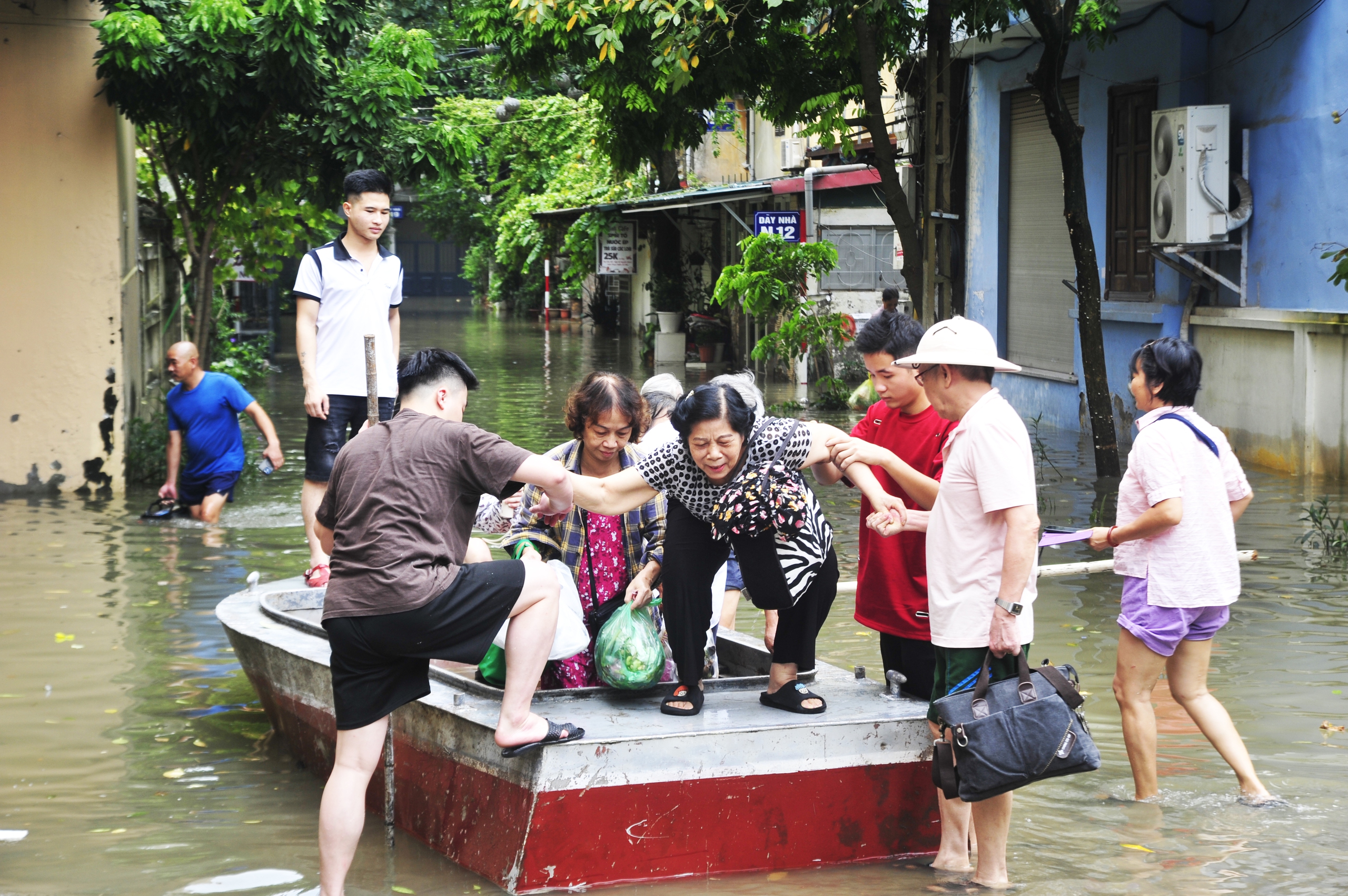 Cách đó vài trăm mét, người dân cũng phải di chuyển bằng thuyền