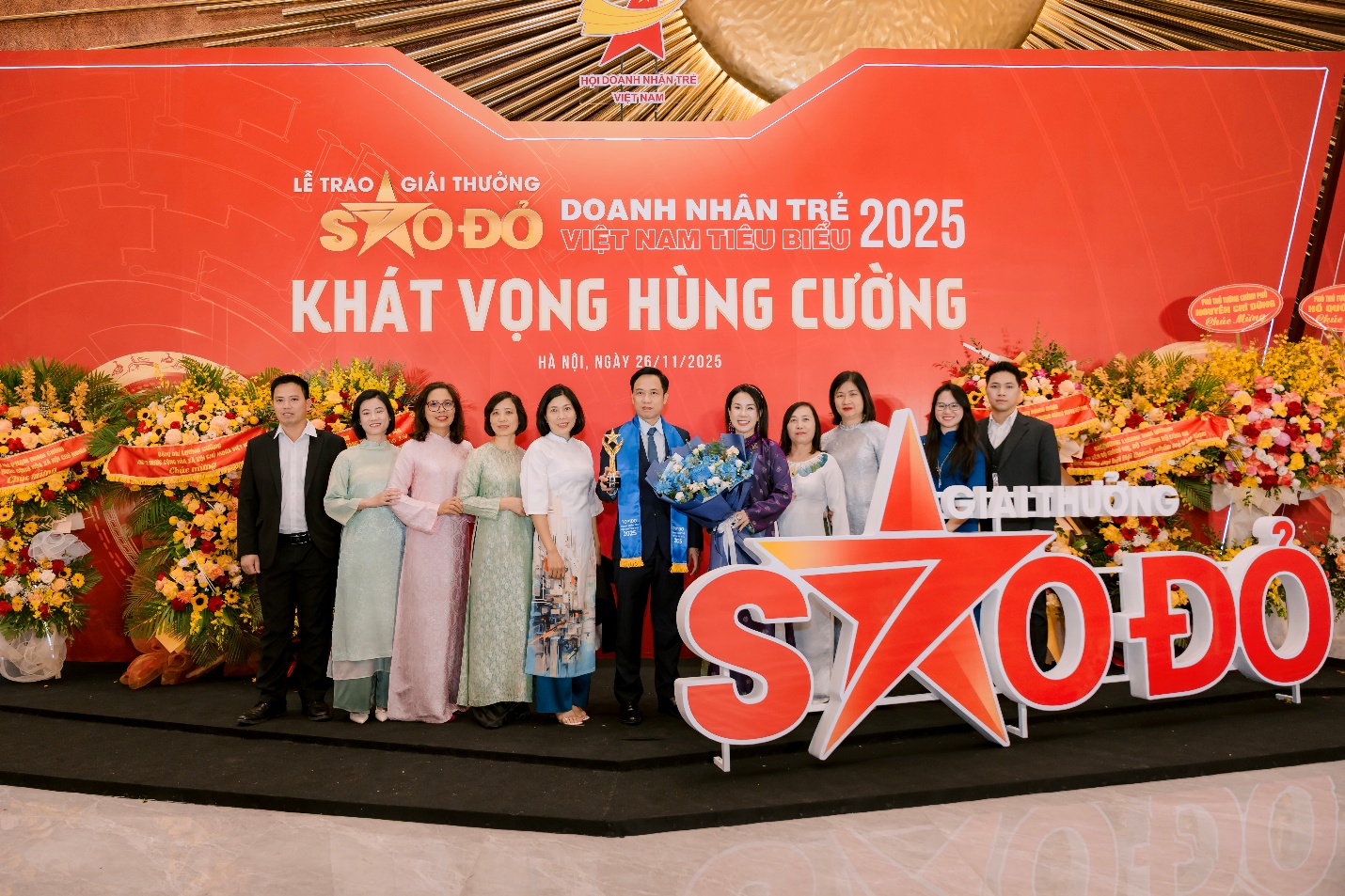 Tổng Giám đốc Dược Nam Hà được vinh danh Doanh nhân trẻ Việt Nam tiêu biểu 2025- Ảnh 3. A group of people standing in front of a sign Description automatically generated