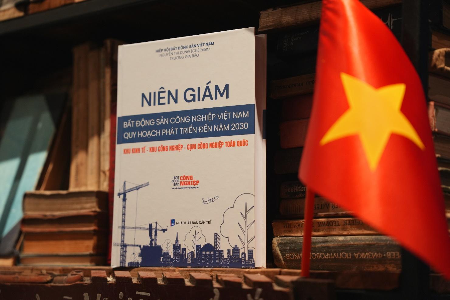 Niên giám Bất động sản Công nghiệp Việt Nam – Bản đồ chiến lược tra cứu khu công nghiệp, cụm công nghiệp toàn quốc- Ảnh 1. A book on a shelf next to a flag AI-generated content may be incorrect.