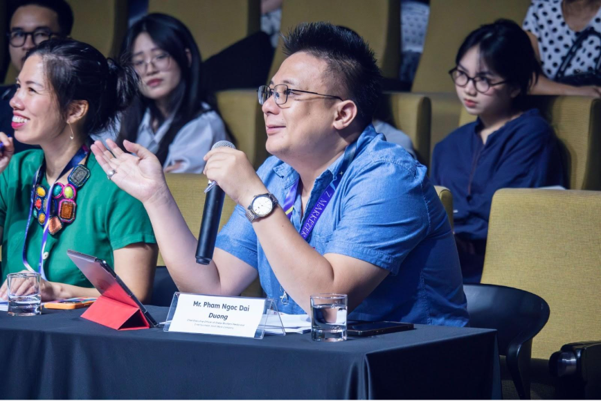 Khi Gen Z kể chuyện Việt bằng ngôn ngữ thời trang- Ảnh 2. A person speaking into a microphone AI-generated content may be incorrect.