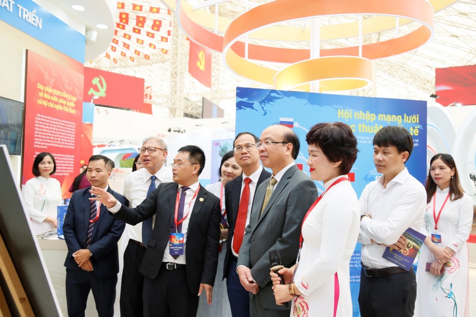 Khai mạc gian triển lãm “Khoa học xã hội Việt Nam nhân dịp kỷ niệm 80 năm Ngày Quốc khánh 2/9- Ảnh 4. A group of people standing in a line AI-generated content may be incorrect.