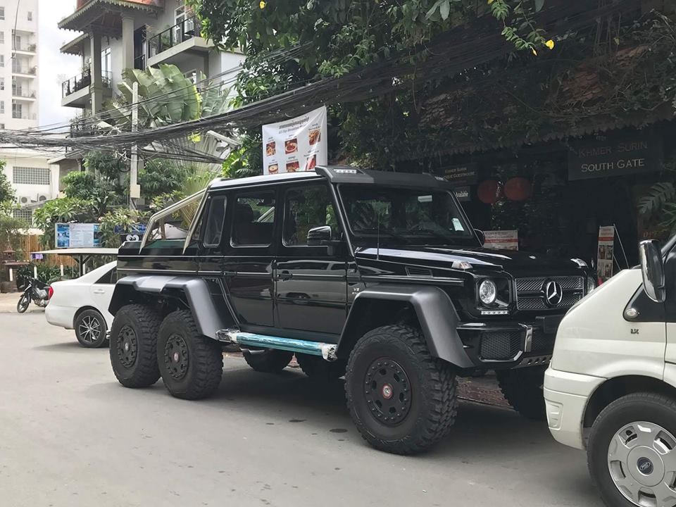 Một chiếc sedan m&agrave;u trắng trở th&agrave;nh g&atilde; t&yacute; hon khi đỗ sau Mercedes-Benz G63 AMG 6x6
