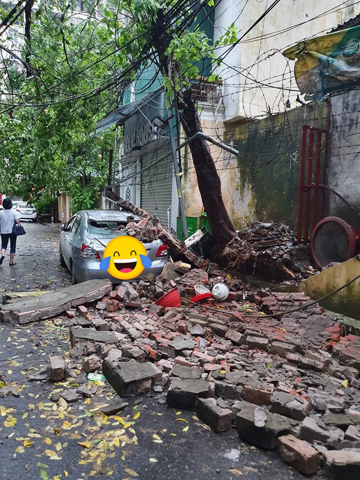 Một chiếc &ocirc; t&ocirc; bị bức tường gạch đổ tr&uacute;ng, dẫn đến hư hỏng nặng