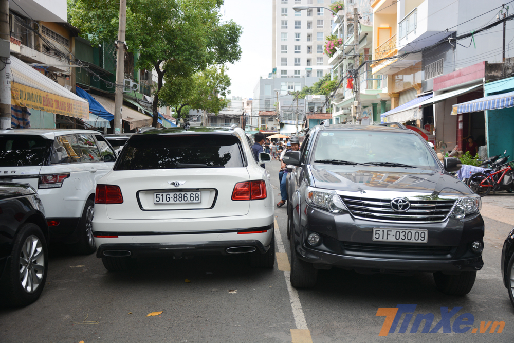 Một chiếc Toyota Fortuner lách qua khe hẹp giữa chiếc Bentley Bentayga và BMW 750 Li đỗ phía bên kia đường chừa lại Một chiếc Toyota Fortuner lách qua khe hẹp giữa chiếc Bentley Bentayga và BMW 750 Li đỗ phía bên kia đường chừa lại