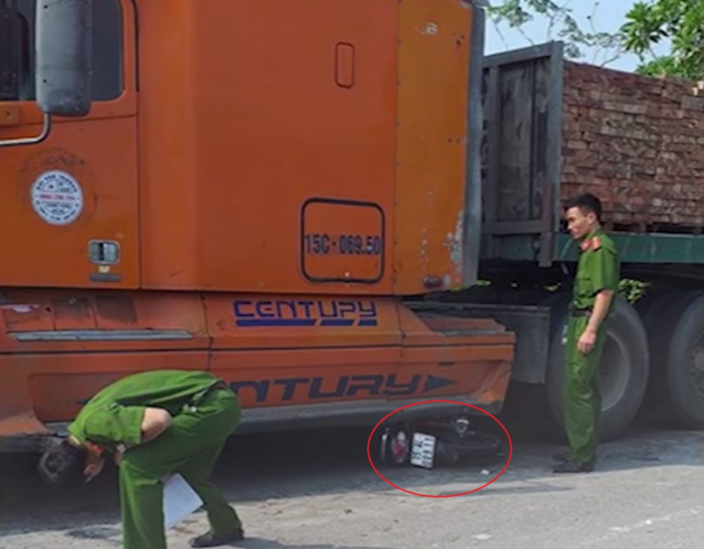 Chiếc xe m&aacute;y chở 2 học sinh nằm dưới gầm xe container