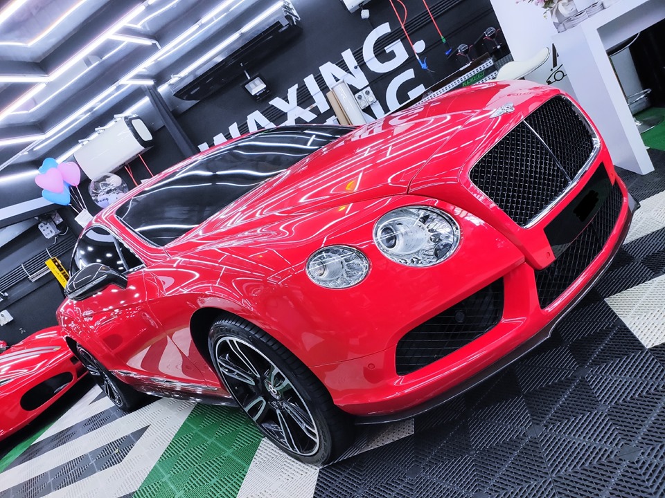 Một chiếc Bentley Continental GT m&agrave;u đỏ được độ body kit carbon. Ph&iacute;a sau c&ograve;n c&oacute; si&ecirc;u xe Ferrari F430 m&agrave;u đỏ