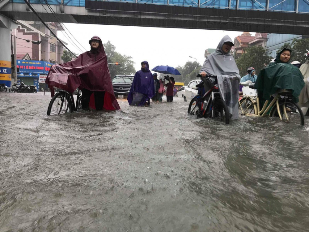 Người dân bì bõm trên tuyến đường ngập