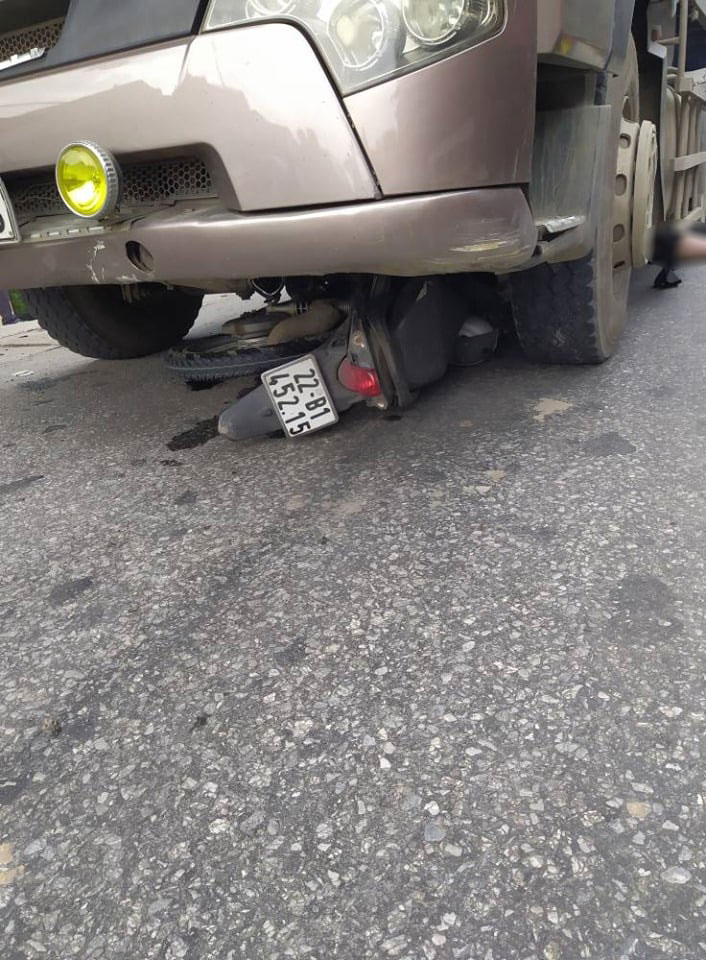 Chiếc xe máy nằm gọn trong gầm xe ben