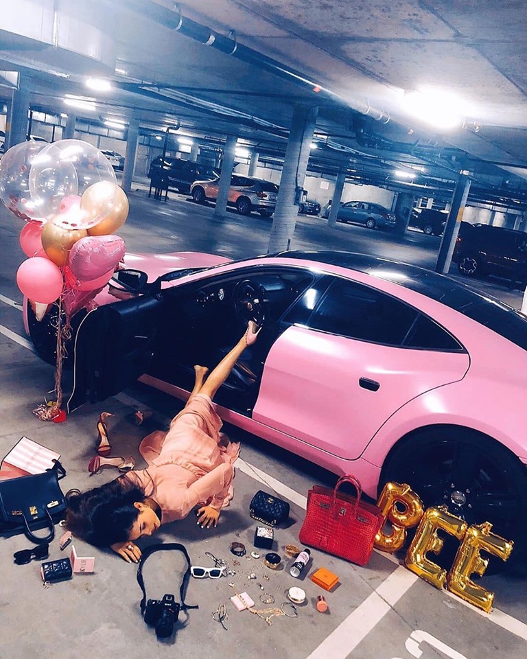 Trào lưu ngã sấp mặt bên siêu xe cũng được Hoa hậu Phạm Hương thể hiện cùng Fisker Karma màu hồng