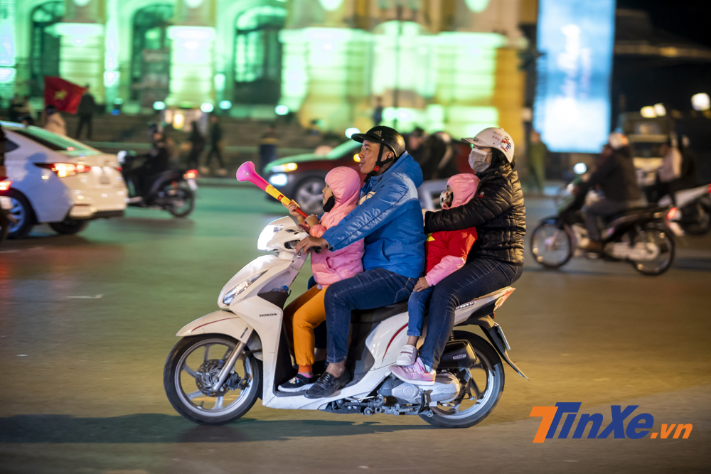 Cả gia đình trên một chiếc xe tay ga cũng xuống phố cổ vũ đội tuyển Việt Nam.a Cả gia đình trên một chiếc xe tay ga cũng xuống phố cổ vũ đội tuyển Việt Nam.a