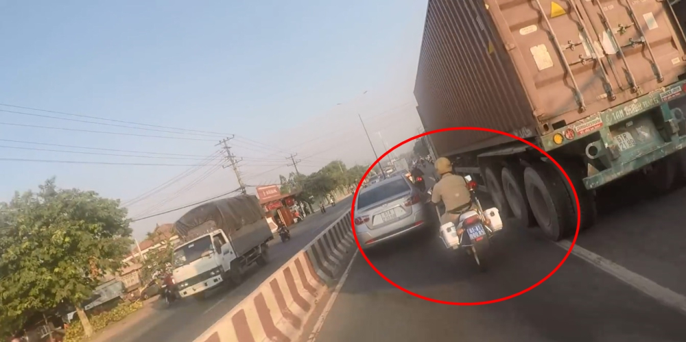 Cảnh sát giao thông lách qua khe hẹp giữa ô tô và xe container Cảnh sát giao thông lách qua khe hẹp giữa ô tô và xe container