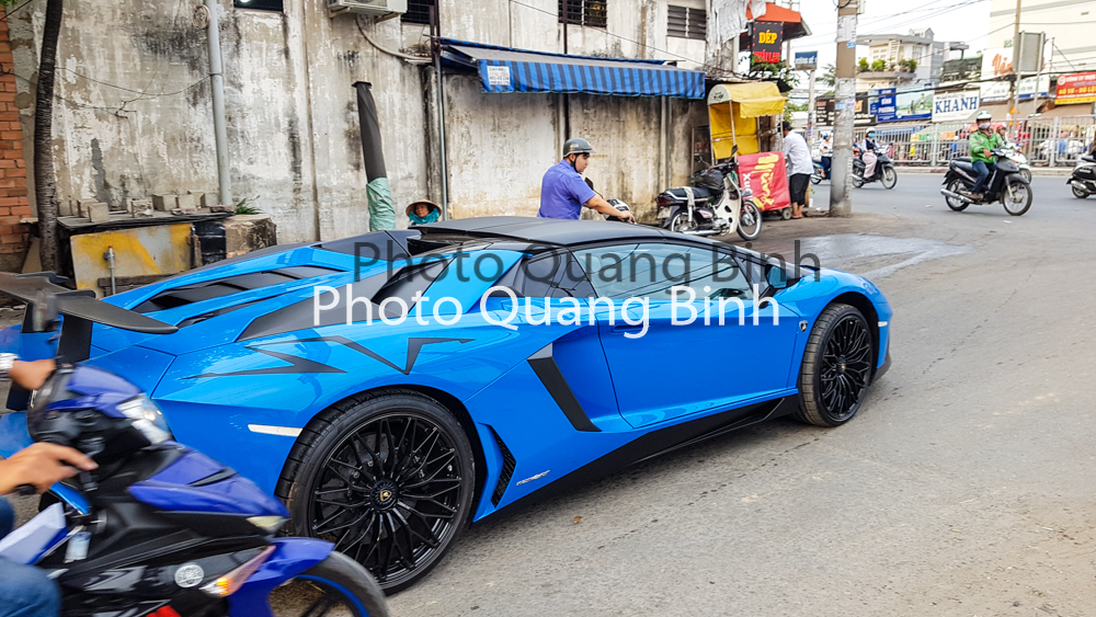 Chưa hết, logo SV của hai chiếc si&ecirc;u xe mui trần Lamborghini Aventador LP750-4 SV Roadster của Việt Nam c&ograve;n c&oacute; sự kh&aacute;c biệt ở vị tr&iacute; đặt. Chiếc Lamborghini Aventador LP750-4 SV mui trần thứ 2 đặt tr&ecirc;n v&ograve;m b&aacute;nh xe ph&iacute;a sau, c&ograve;n với chiếc đầu ti&ecirc;n đặt dưới thấp, b&ecirc;n h&ocirc;ng b&aacute;nh xe sau. 