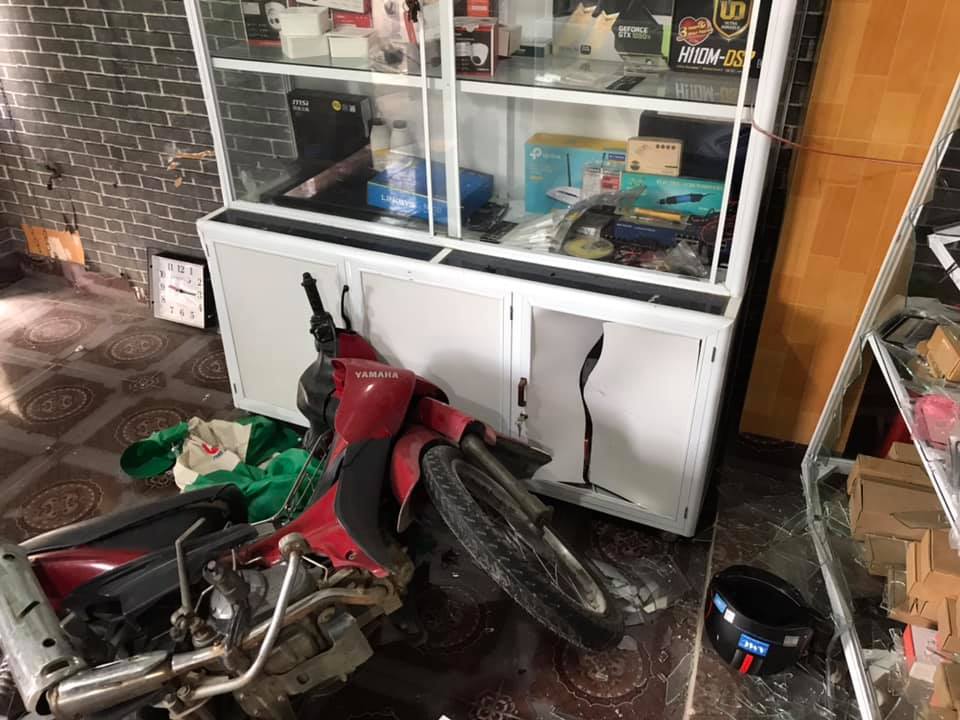 Hai chiếc xe máy nằm đổ trong cửa hàng sửa chữa máy tính sau vụ tai nạn