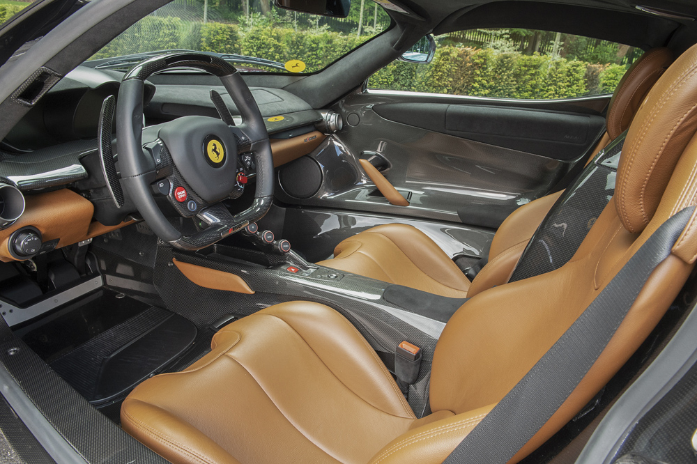  B&ecirc;n trong khoang l&aacute;i chiếc si&ecirc;u xe Ferrari LaFerrari mang m&agrave;u sơn Rosso Vinaccia c&oacute; nội thất bọc da m&agrave;u n&acirc;u Pelle Chiodi Di Garofano phối c&ugrave;ng da m&agrave;u đen cơ bản v&agrave; cả sợi carbon b&oacute;ng. T&ocirc;ng m&agrave;u độc đ&aacute;o n&agrave;y được lấy cảm hứng từ chiếc Ferrari 166MM c&ugrave;ng thuộc sở hữu của vị chủ nh&acirc;n chiếc Ferrari LaFerrari n&agrave;y. 