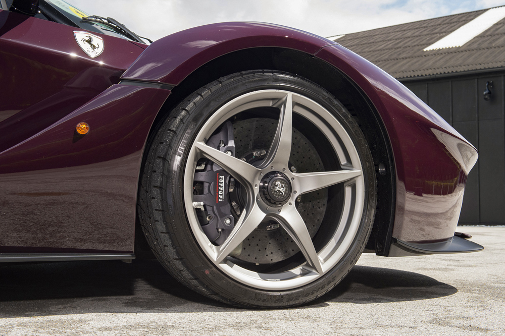  Ngo&agrave;i bộ &aacute;o t&iacute;m Rosso Vinaccia, chiếc si&ecirc;u xe Ferrari LaFerrari n&agrave;y c&ograve;n được trang bị bộ m&acirc;m 5 chấu ti&ecirc;u chuẩn kho&aacute;c m&agrave;u n&ograve;ng s&uacute;ng c&ugrave;ng logo b&aacute;nh xe m&agrave;u trắng-đen tương phản. Tất nhi&ecirc;n l&agrave; ngoại thất xe c&ograve;n c&oacute; nhiều chi tiết carbon. 