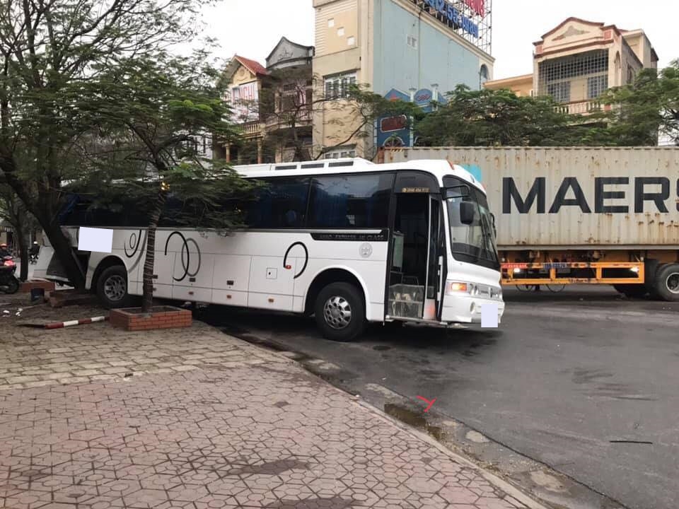 Chiếc xe kh&aacute;ch với nửa đu&ocirc;i xe g&aacute;c hẳn l&ecirc;n vỉa h&egrave;