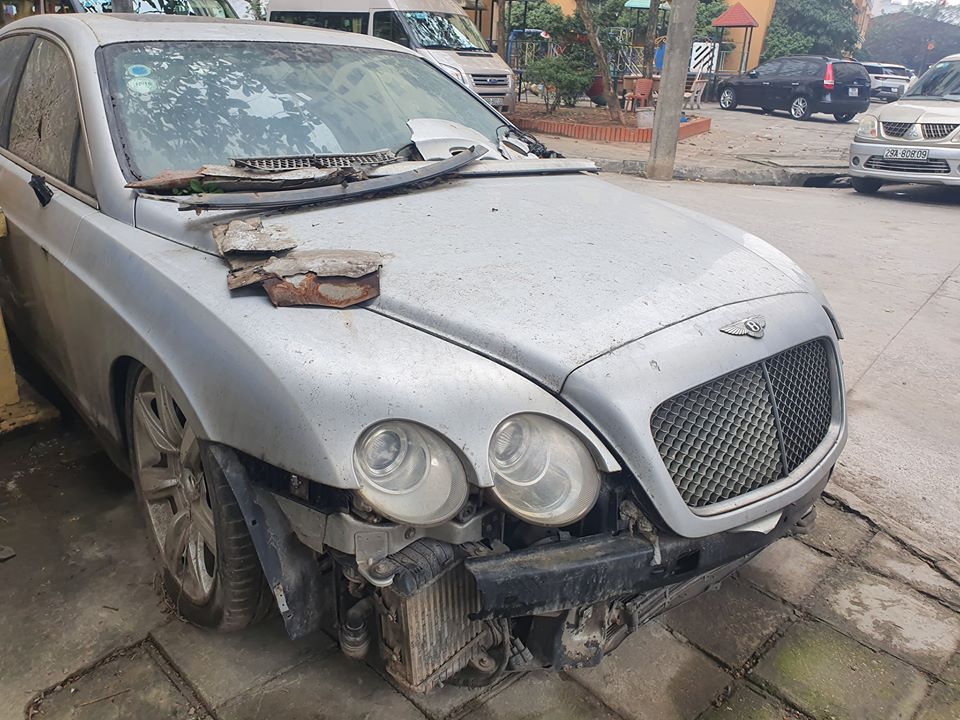 Những hư hỏng của chiếc xe siêu sang Bentley Continental Flying Spur màu xám là khá nặng. Ngoại thất xe bám bụi dày đặc và còn có cả đất. Cửa kính phía bên ghế phụ vỡ. Những hư hỏng của chiếc xe siêu sang Bentley Continental Flying Spur màu xám là khá nặng. Ngoại thất xe bám bụi dày đặc và còn có cả đất. Cửa kính phía bên ghế phụ vỡ.
