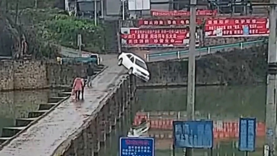 Chiếc &ocirc; t&ocirc; m&agrave;u trắng do anh Zhang cầm l&aacute;i lao xuống s&ocirc;ng