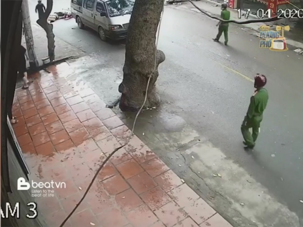 Lực lượng c&ocirc;ng an chốt chặn gần đ&oacute;. Ph&iacute;a xa l&agrave; chiếc xe m&aacute;y c&ugrave;ng một người ng&atilde; ra đường