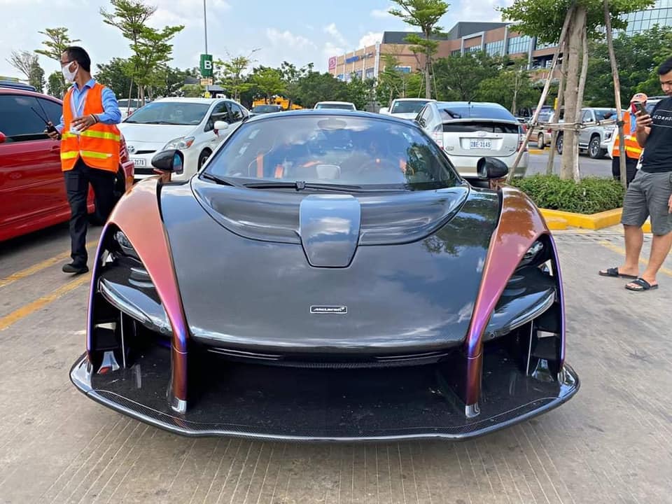 Còn siêu xe triệu đô McLaren Senna của đại gia quận 12 lại có màu tím, cam và xanh. Chưa hết, toàn bộ phần nắp capô của chiếc McLaren Senna sắp được đưa qua cửa khẩu ở Campuchia để về Việt Nam là bằng carbon, chi tiết này được đánh giá đẹp mắt và tất nhiên là đắt tiền hơn so với chiếc McLaren Senna ở Mỹ được sơn đổi màu.