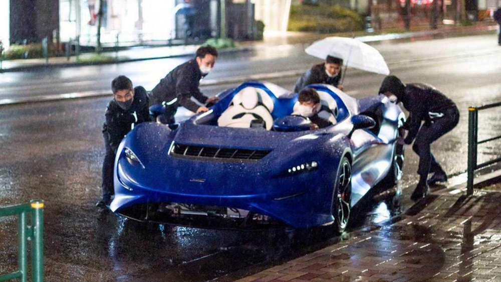 5 người đ&agrave;n &ocirc;ng vật lộn với chiếc McLaren Elva trong cơn mưa lớn