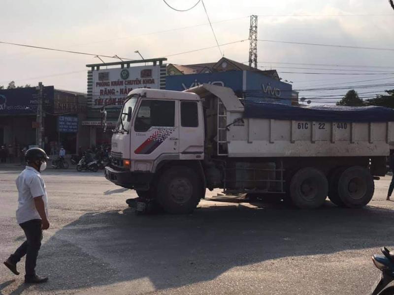 Chiếc xe m&aacute;y nằm dưới gầm, ngay b&aacute;nh xe ph&iacute;a trước b&ecirc;n ghế phụ của xe ben