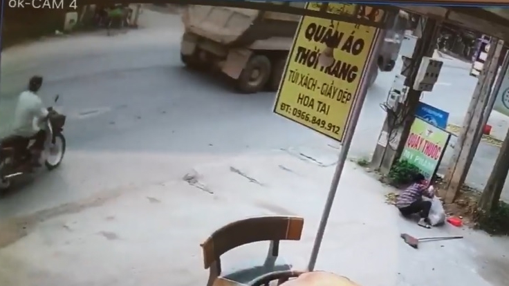 Người đàn ông điều khiển xe máy chạy ngay sau đuôi xe ben trước khi sang đường Người đàn ông điều khiển xe máy chạy ngay sau đuôi xe ben trước khi sang đường