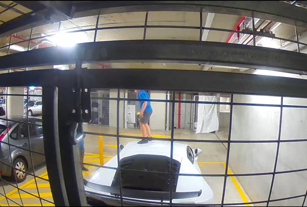 Một đứa trẻ đứng trên nóc của chiếc siêu xe Lamborghini Huracan