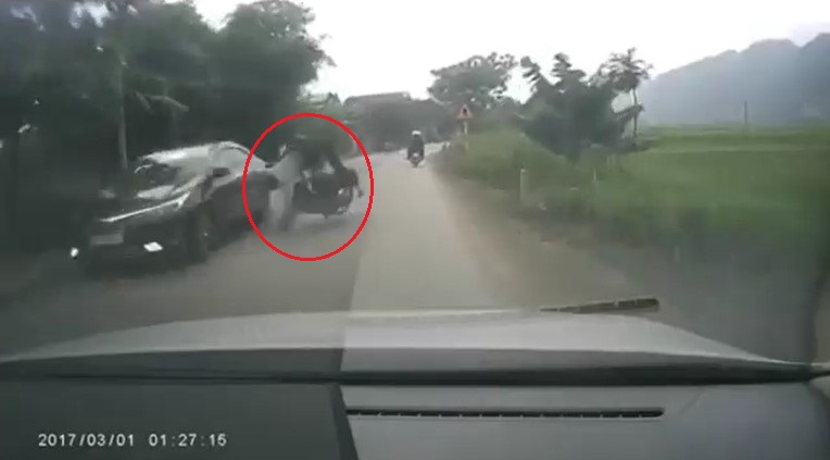 2 người đi xe m&aacute;y bị hất văng ra đường sau c&uacute; va chạm với chiếc Toyota Corolla Altis đang đỗ