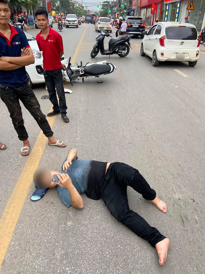 Nam thanh ni&ecirc;n nằm dưới đường v&agrave; xem điện thoại sau khi xảy ra tai nạn