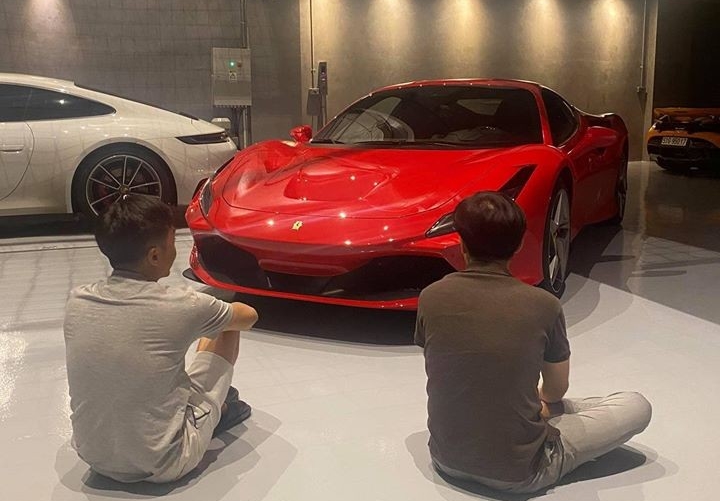 Chồng của Đàm Thu Trang cùng bạn ngồi ngắm vẻ đẹp của siêu ngựa Ferrari F8 Tributo mới về garage của mình. Bên trái còn có Porsche 911 Carrera S 2020 và phía xa bên phải là McLaren 720S