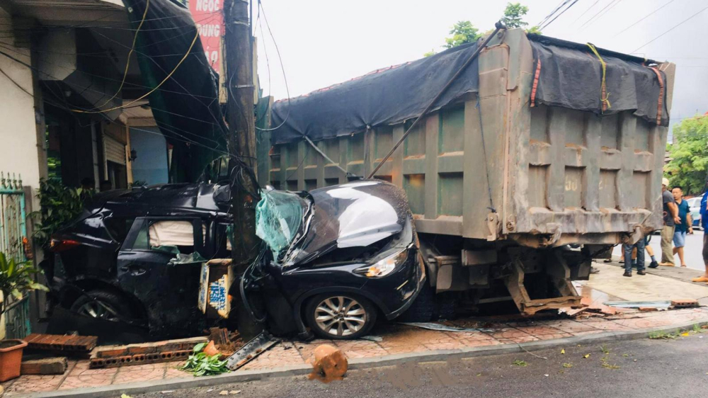 Chiếc &ocirc; t&ocirc; Mazda CX-5 bị kẹp giữa chiếc xe ben v&agrave; cột điện