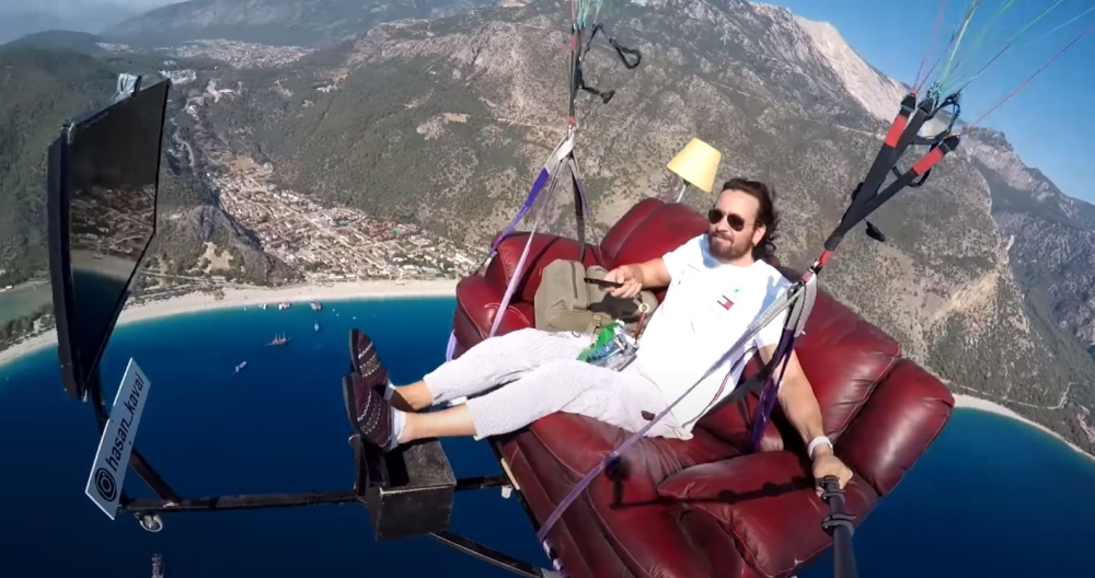 Hình ảnh Hasan Kaval thư giãn xem TV khi bay dù lượn khiến cư dân mạng kinh ngạc